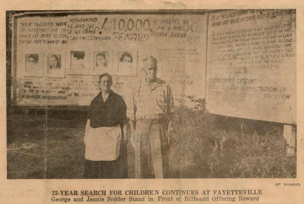 A newspaper photo of George and Jennie Sodder in front of the billboard