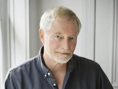 A portrait of a man wearing a dark shirt