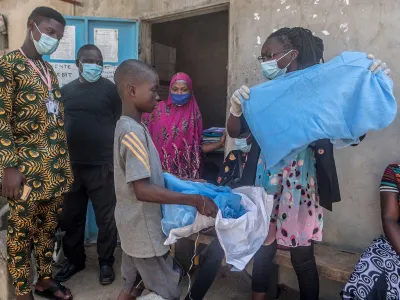 A young boy in Benin, in West Africa, receives a bed net designed to help prevent malaria. 