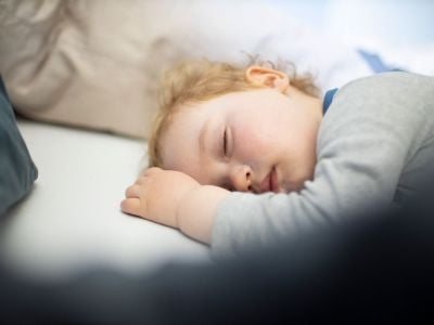 A child sleeps in his parents bed.