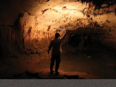 Ruiz-Redondo examines a partially flooded chamber of Cova Dones.&nbsp;