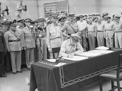 The 31-star Perry flag is visible in the background of this photo, which shows United States General Douglas MacArthur signing the official Japanese surrender on September 2, 1945.