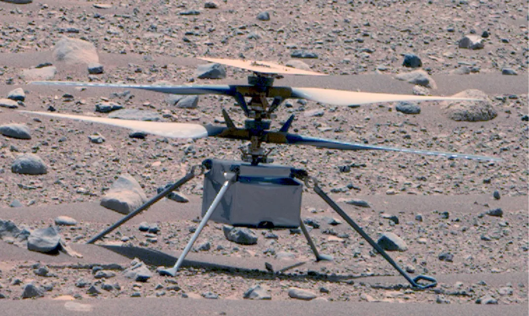 Ingenuity helicopter with its rotor blades out on the rocky Martian surface