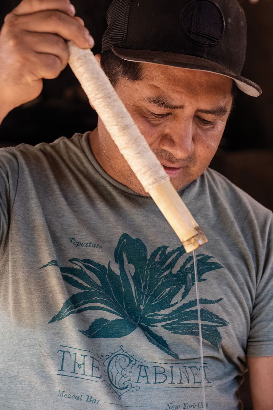 Fredy Chávez of Palenque Totoy checks a batch of mezcal