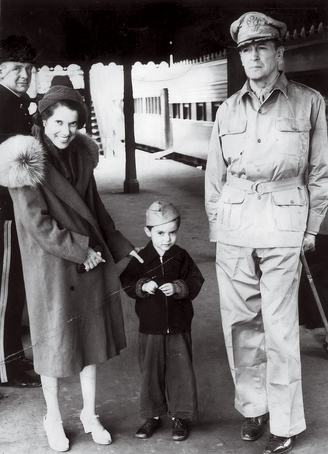 General Douglas MacArthur stands with his wife and child